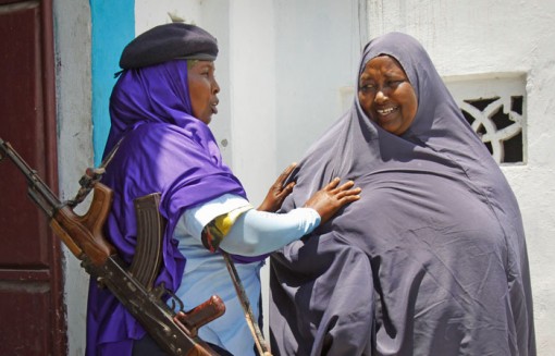 A female Somali soldier, left, searches a civilian before she enters a police station in Mogadishu, the nations capital, on Sunday, March 30, 2014. There are at least 1,500 women serving in the Somali army, though most are not allowed to fight on the front lines. 