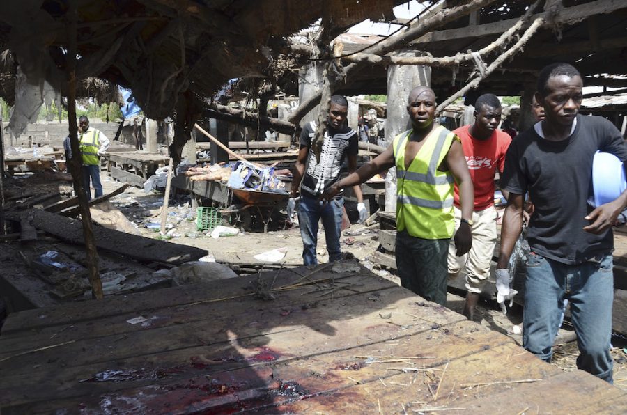 Rescue workers at the site of  a suicide bomb attack at a market in Maiduguri , Nigeria, Tuesday, June 2, 2015.  Boko Haram attacked the northeastern Nigerian city of Maiduguri on Tuesday with deafening explosions from the west and a suicide bombing near the center that witnesses said killed as many as 20 people.  (AP Photo/Jossy Ola)