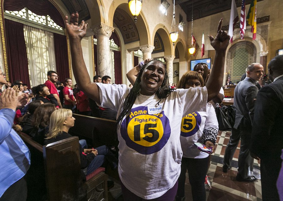 Workers react as the Los Angeles City Council votes 13-1 to raise the minimum wage to $15 an hour by 2020, but a second vote is required for final approval because the tally was not unanimous, in Los Angeles, Wednesday, June 3, 2015. Nonetheless, Council President Herb Wesson stressed to the cheering crowd that the outcome was all but certain. (AP Photo/Damian Dovarganes )
