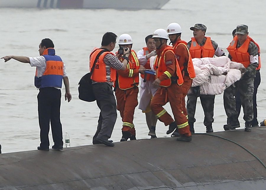 Rescuers carry a survivor pulled from the capsized cruise ship on the Yangtze River in Jianli in central Chinas Hubei province Tuesday June 2, 2015.  Divers on Tuesday pulled survivors from inside the overturned cruise ship, state media said, giving some small hope to an apparently massive tragedy with well over 400 people still missing on the river. (Chinatopix Via AP)