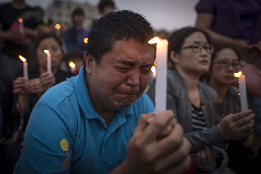 A man reacts during a candle light vigil by locals and family members of passengers onboard the capsized cruise ship in Jianli county  in southern Chinas Hubei province Thursday.  Rescuers cut three holes into the overturned hull of a river cruise ship in unsuccessful attempts to find more survivors Thursday.  (Chinatopix Via AP) 