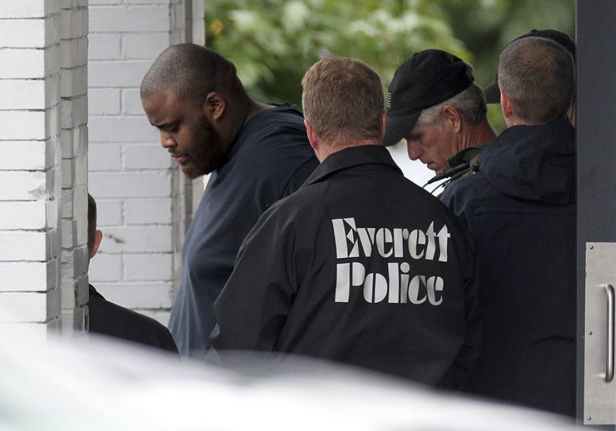 In this Tuesday, June 2, 2015 photo, authorities remove David Wright from a house in Everett, Mass., after a day-long police investigation at the property. Wright, a relative of Usaama Rahim, was ordered held Wednesday on a charge of conspiracy with intent to obstruct a federal investigation in the Rahim case. Rahim, who was under surveillance by terrorism investigators, was shot and killed after he wielded a knife at a Boston police officer and an FBI agent. (Boston Herald/John Wilcox via AP)