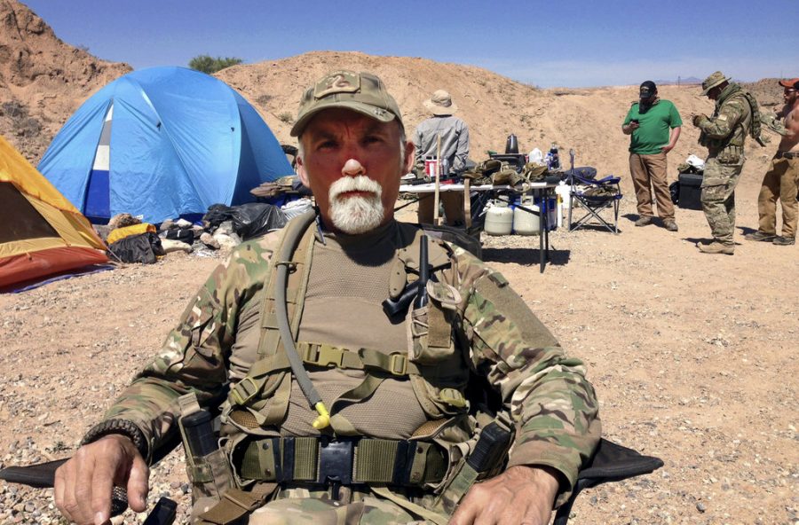 In this April 16, 2014 file photo, Gerald Jerry DeLemus, of Rochester, N.H., sits with a group of self-described militia members camping on rancher Cliven Bundys ranch near Bunkerville, Nev. DeLemus is set to become the first person sentenced to federal prison on Wednesday, May 31, 2017, for his role in an armed confrontation with U.S. agents near Nevada rancher Cliven Bundys ranch in 2014 on (AP Photo/Ken Ritter)

