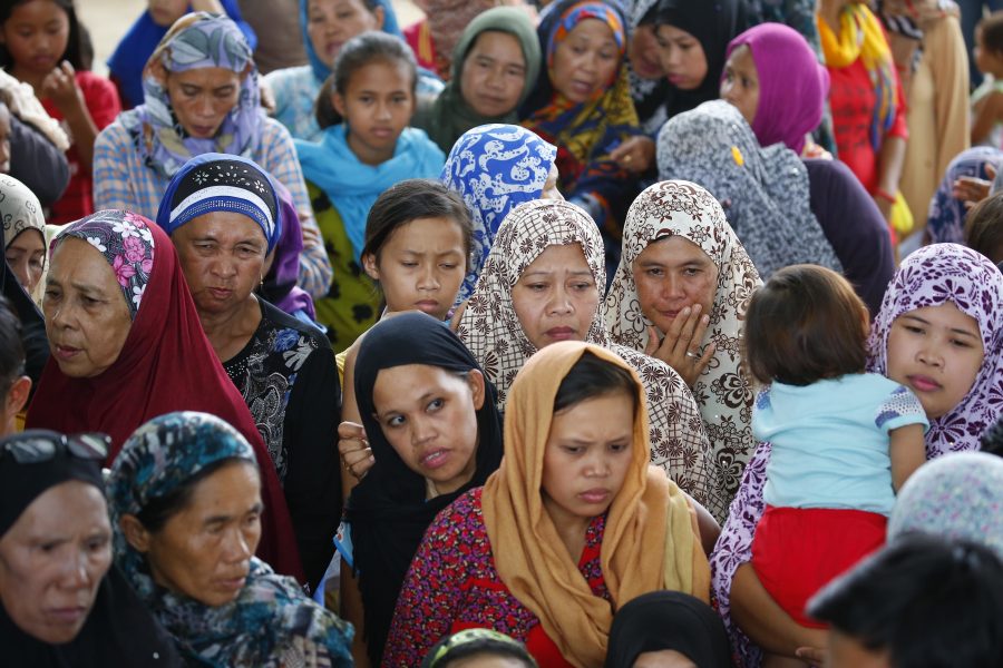 Displaced residents of Marawi city wait for their other relatives after queueing up to receive relief and food supplies at an evacuation center in Balo-i township,  Lanao del Norte province, southern Philippines Wednesday, May 31, 2017. Tens of thousands of residents are now housed in different evacuation centers as Government troops fight with Muslim militants who laid siege in Marawi city Tuesday of last week.(AP Photo/Bullit Marquez)
