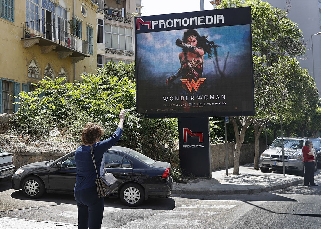 <p>A woman waves for a taxi as she stands in front of a digital billboard promoting the 2017 Wonder Woman movie in Beirut, Lebanon on May 30. Lebanon's ministry of economy says it has asked the country's security agency to ban the movie because its lead actress, Gal Gadot, is an Israeli.</p>