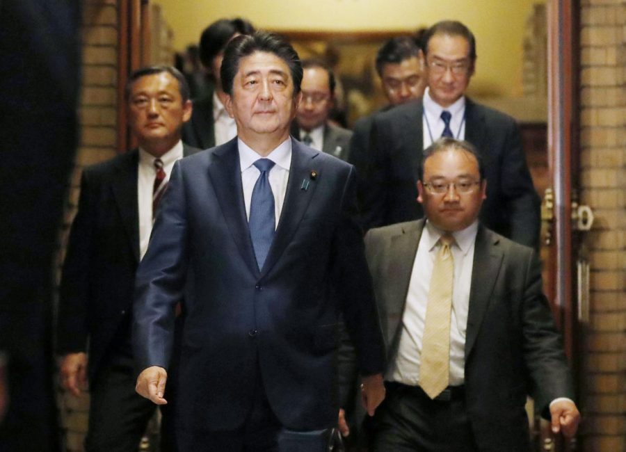 Japanese Prime Minister Shinzo Abe goes to meet journalists after a phone call with the U.S. president.