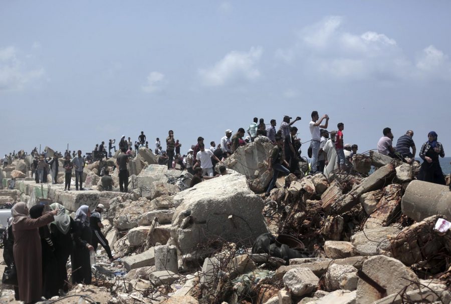 Palestinians watch two fishing boats sail with 20 people