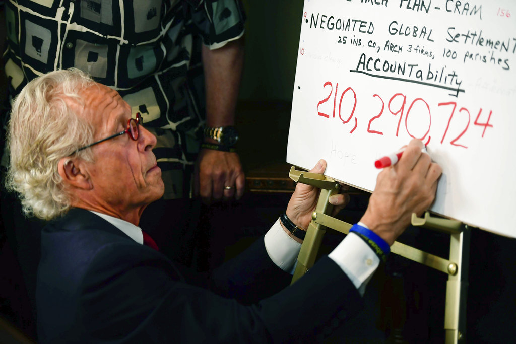 Attorney Jeff Anderson draws a comma while writing down the sum of the settlement reached between the Archdiocese of St. Paul and Minneapolis and clergy sexual abuse victims at his office on May 31 in St. Paul, Minnesota