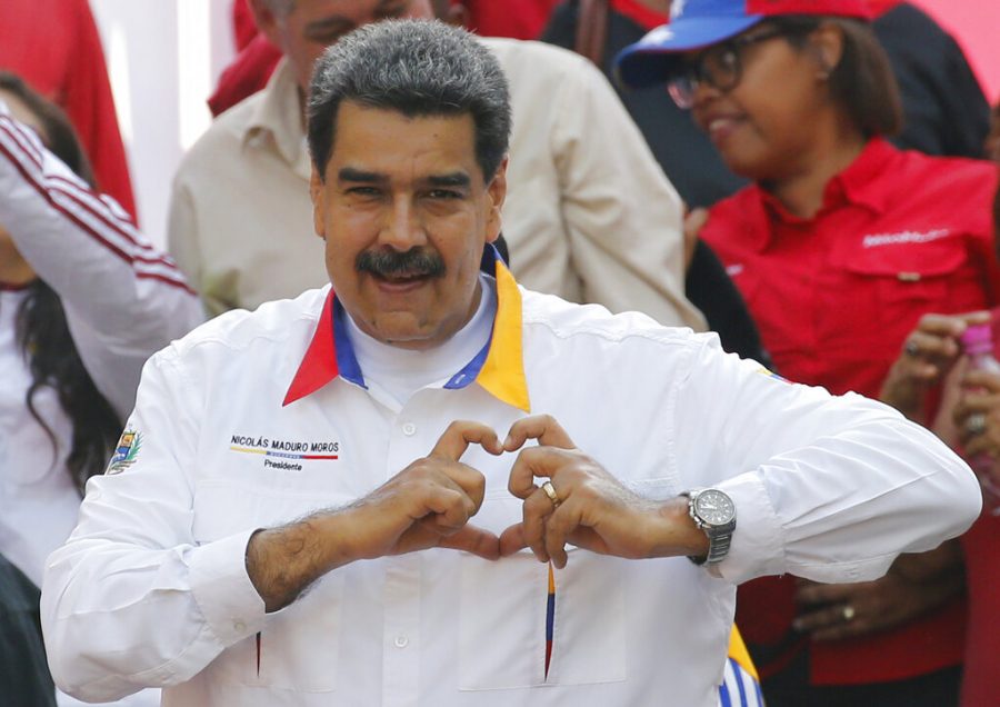 In this May 20, 2109 photo, Venezuelas President Nicolas Maduro flashes a hand-heart symbol to supporters outside Miraflores presidential palace in Caracas, Venezuela. Maduro said Thursday, May 23, 2019, that he is inviting Chinas Huawei to help set up a 4G network in Venezuela, prompting opposition leader Juan Guaidó to accuse him of having an absolute disconnection with reality. 