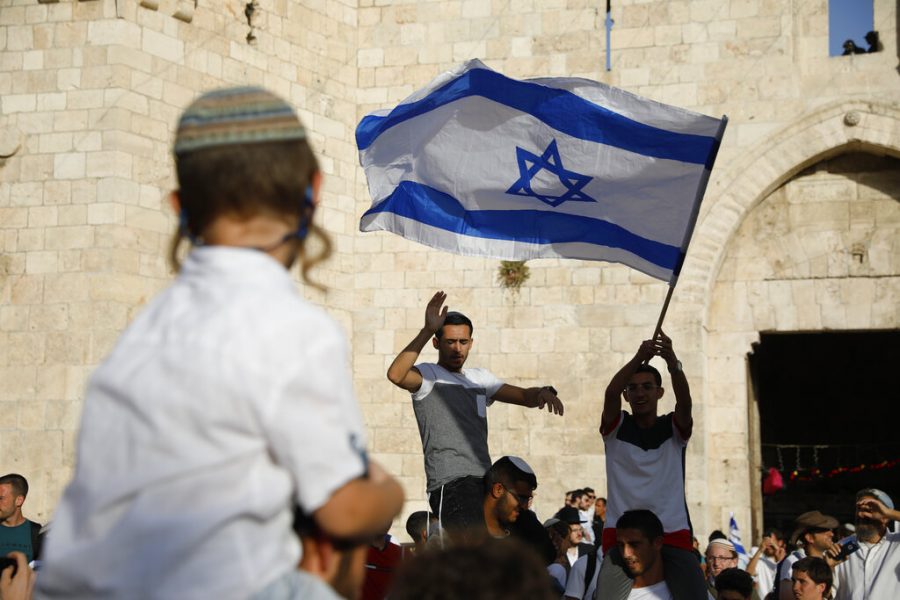 CORRECTS TO READ IN FRONT OF THE DAMASCUS GATE - Israelis wave national flags in front of the Damascus Gate of the Jerusalems Old City Sunday, June 2, 2019, during Jerusalem Day, an Israeli holiday celebrating the capture of the Old City during the 1967 Mideast war. (AP Photo/Ariel Schalit)
