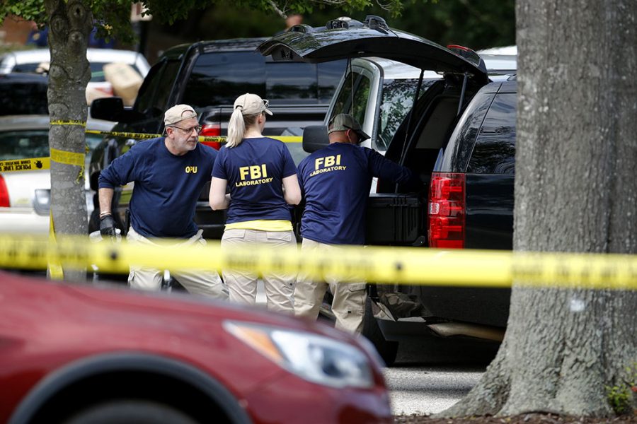 Members of the FBI load equipment into a vehicle as they work in a parking lot outside the municipal building that was the scene of a shooting Saturday in Virginia Beach, Va. DeWayne Craddock, a longtime city employee, opened fire at the building Friday before police shot and killed him, authorities said. 