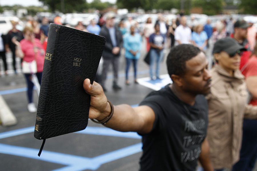 Mike Harris, of Virginia Beach, Va., holds a Bible as he prays during a vigil in response to a shooting at a municipal building in Virginia Beach, Va., June 1, 2019. A longtime city employee opened fire at the building Friday before police shot and killed him, authorities said.