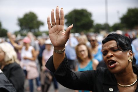 Virginia Beach, Va., council member Sabrina Wooten holds her hand out as she sings during a vigil in response to a fatal shooting at a municipal building in Virginia Beach, Va., June 1. A longtime city employee opened fire at the building Friday before police shot and killed him, authorities said. 