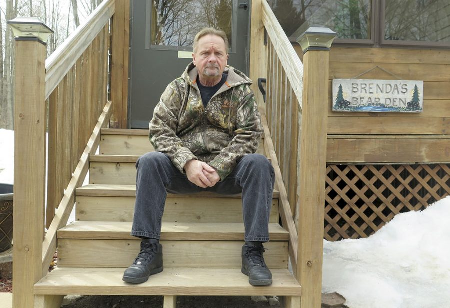 In this April 10, 2019 photo, Wayne Sankey sits on the front steps of his Lakewood, Wis. home where he is the neighbor of Raymand Vannieuwenhoven, who authorities say is the suspect in a cold-blooded 43-year-old cold case murder. The news of Vannieuwenhovens arrest hit Sankey, 68, like a thunderbolt.   Prosecutors said they used DNA and genetic genealogy to connect Vannieuwenhoven to the 1976 killings of a young couple, David Schuldes and Ellen Matheys. (AP Photo/Ivan Moreno)