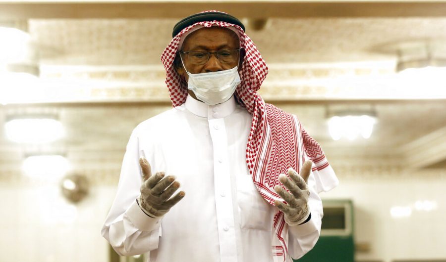A Saudi worshipper wears a white face mask and gloves as he prays dawn prayers at al-Mirabi Mosque in Jiddah, Saudi Arabia on May 31.