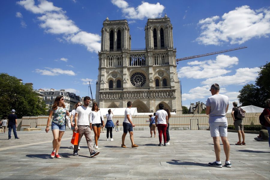 Tourists view the newly repaired Norte Dame cathedral.