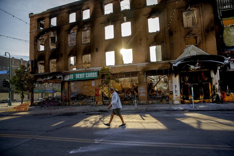 A man walks past a damaged building following overnight protests over the death of George Floyd.