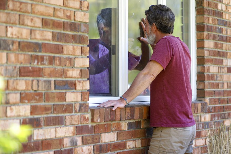 Jack Campise talks with his mother, Beverly Kearns, through her apartment window at the Kimberly Hall North nursing home, May 14, in Windsor, Connecticut. The coronavirus has had no regard for health care quality or ratings as it has swept through nursing homes around the world, killing efficiently even in highly rated care centers. Preliminary research indicates the numbers of nursing home residents testing positive for the coronavirus and dying from COVID-19 are linked to location and population density — not care quality ratings. 