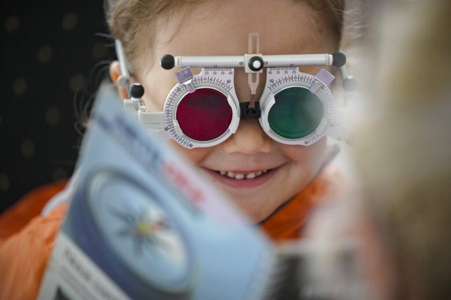 A child smiles during an eyesight examination 