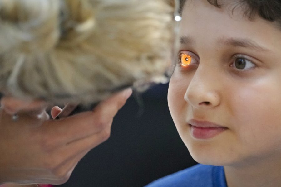 A volunteer tests a boys vision in Romania.