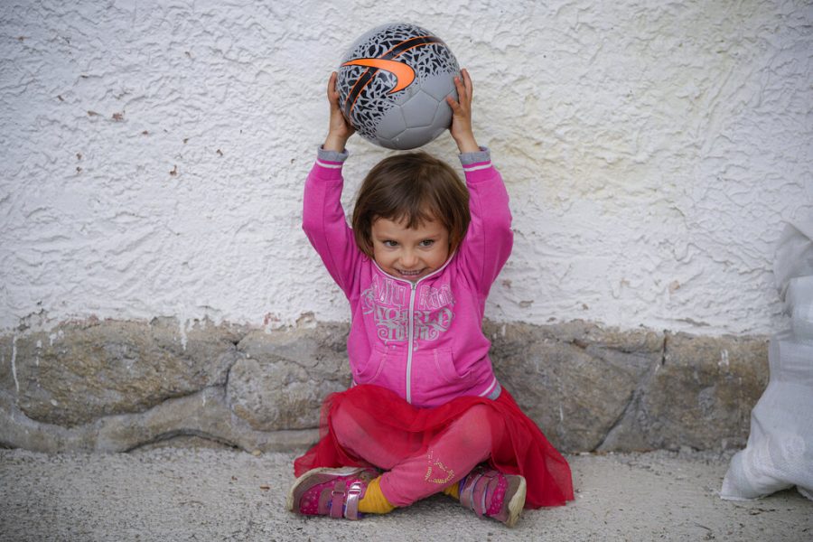 A little girl holds a ball during an eyesight examination.