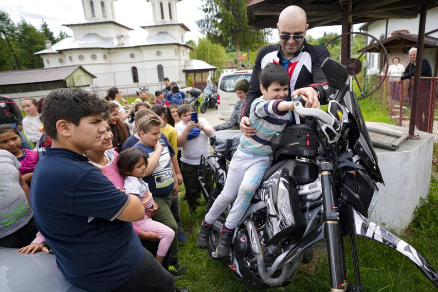 Children pose on motorcycles belonging to the members of the group Bikers for Humanity