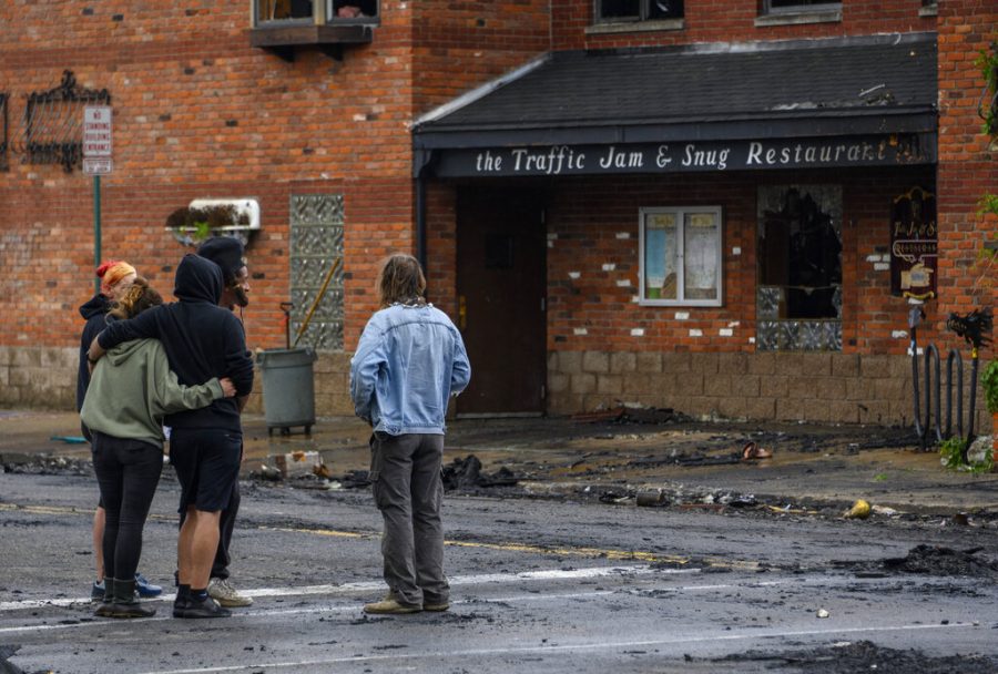 People watch as Detroit Fire Department firefighters continue to pour water after an overnight fire at Traffic Jam and Snug Restaurant, Friday, May 27, 2022. (Andy Morrison/Detroit News via AP)