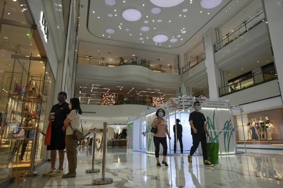 Residents wearing face masks visit reopened retail shops inside a mall