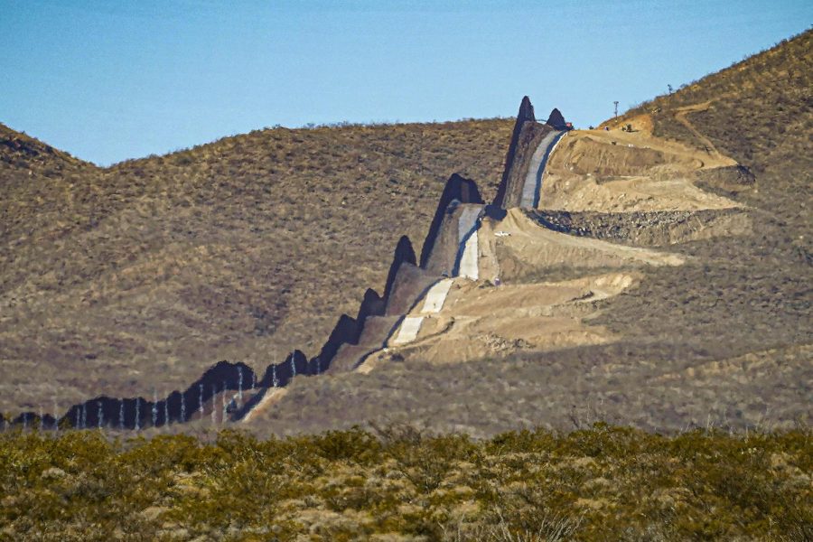 A U.S. government-built section of border wall snakes through the Sonoran Desert just west of the San Bernardino National Wildlife Refuge, separating Mexico, left, and the United States, Dec. 9, 2020, in Douglas, Ariz. A prosecutor told jurors in closing arguments at a criminal trial, Tuesday, May 31, 2022, that there is overwhelming evidence that organizers of a We Build The Wall campaign to raise money for a wall along the U.S. southern border defrauded investors. 