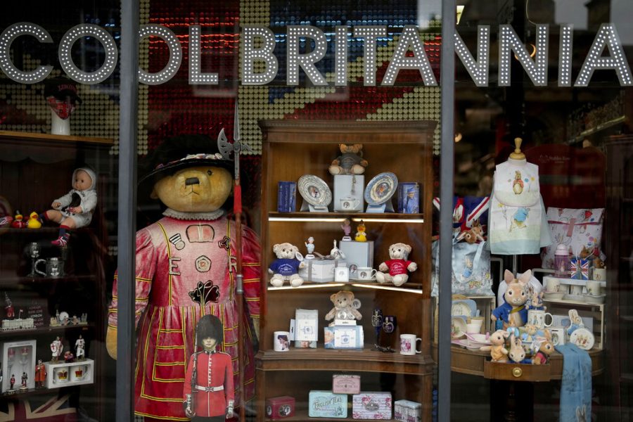 FILE - Souvenir items for Britains Queen Elizabeth IIs Platinum Jubilee are displayed for sale in the front window of the Cool Britannia store near Buckingham Palace, in London, Thursday, May 26, 2022. Britain is getting ready for a party featuring mounted troops, solemn prayers — and a pack of dancing mechanical corgis. The nation will celebrate Queen Elizabeth II’s 70 years on the throne this week with four days of pomp and pageantry in central London. (AP Photo/Matt Dunham, File)
