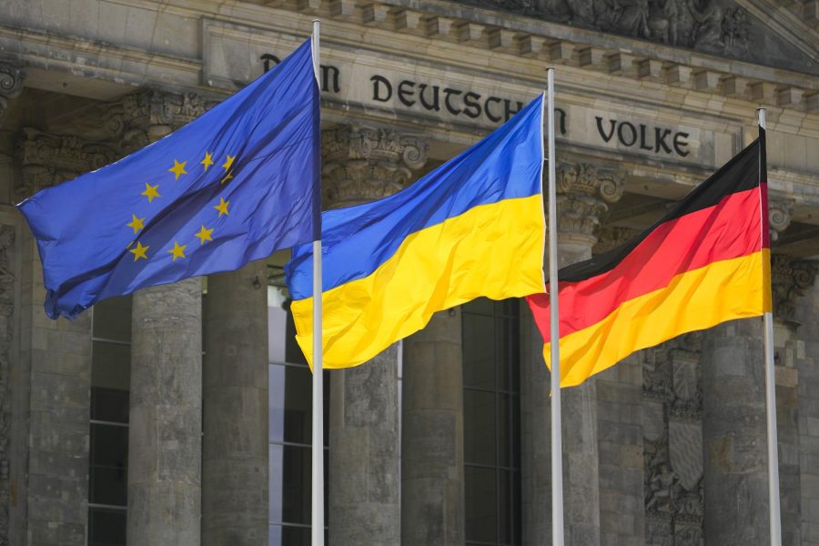The Ukrainian national flag waves between the Europa fag, left, and the German national flag, right, in front of the Reichstag building during a debate at the German parliament Bundestag in Berlin, Germany, June 1. The inscription reads: The German People.