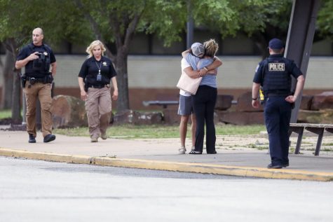 Two people hug outside at Memorial High School where people were evacuated from the scene of a shooting at the Natalie Medical Building Wednesday, June 1, 2022. in Tulsa, Okla. Multiple people were shot at a Tulsa medical building on a hospital campus.