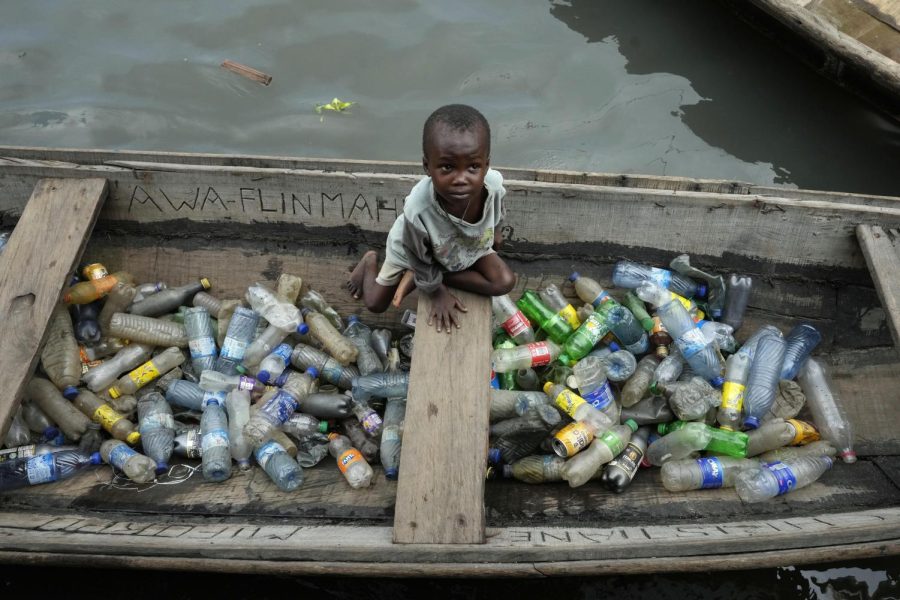 A child sits in a canoe with empty plastic bottles he collected to sell for recycling in the floating slum of Makoko in Lagos, Nigeria, Nov. 8, 2022.