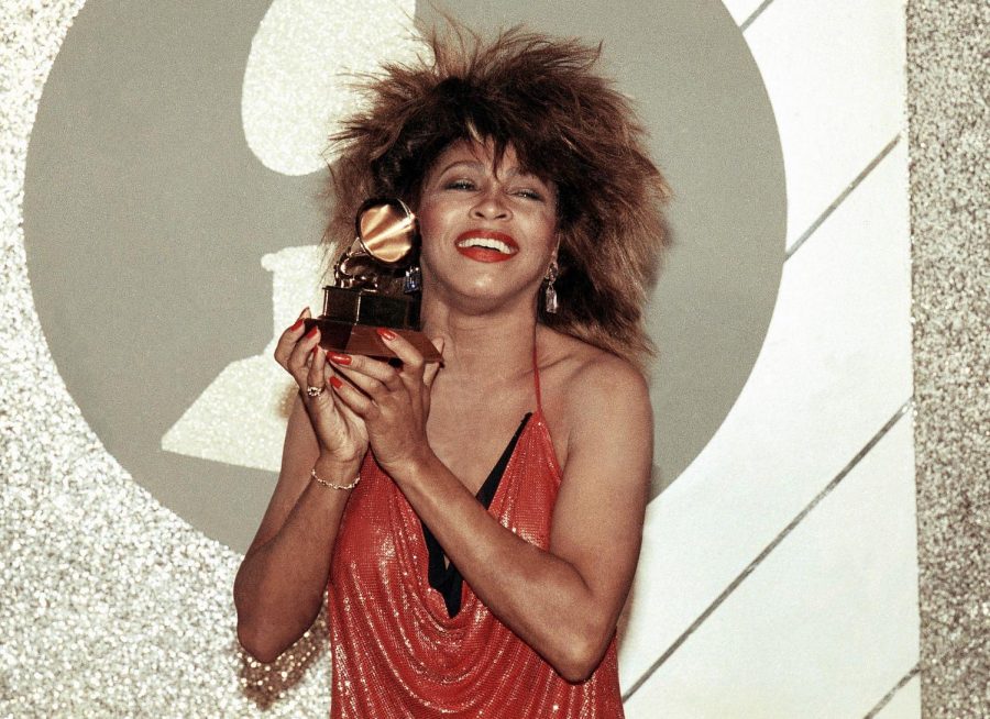 Tina Turner holds a grammy.