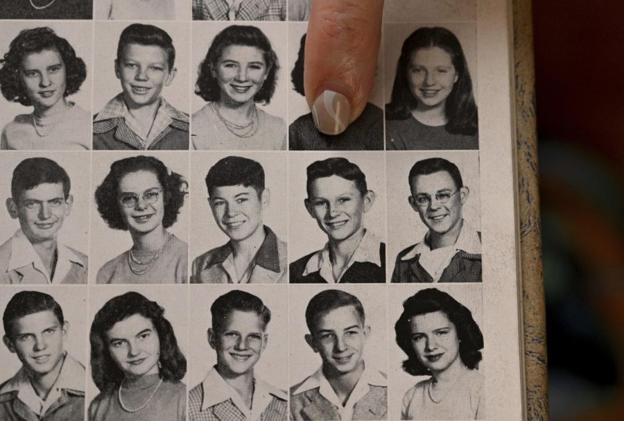 Judy Wade places her finger on a black-and-white photo of Luther Story in a yearbook.