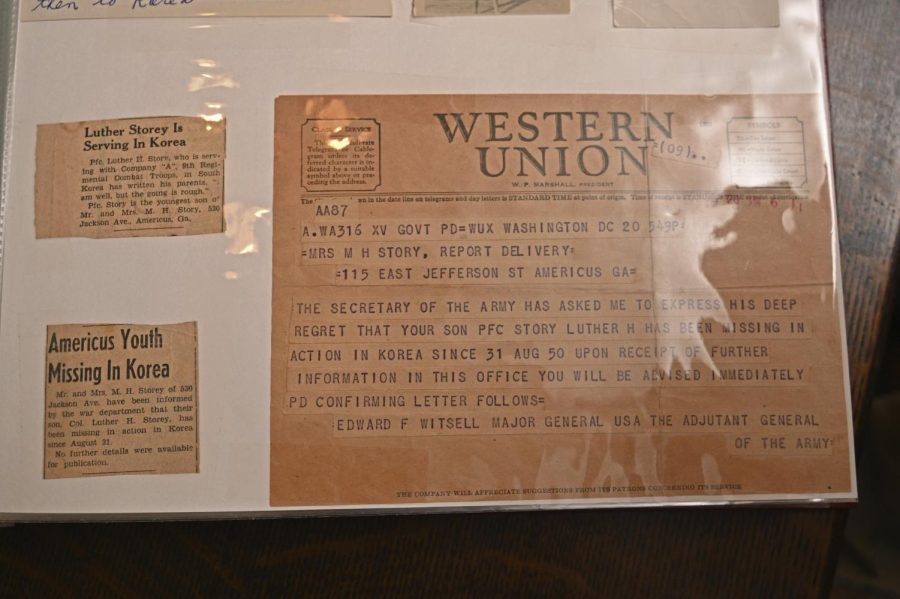 A scrapbook with two newspaper clips and a report delivery is shown.