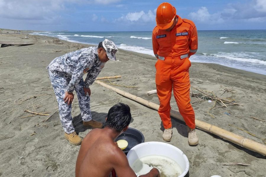 Philippine Coast Guard personnel talking to a man on the beach
