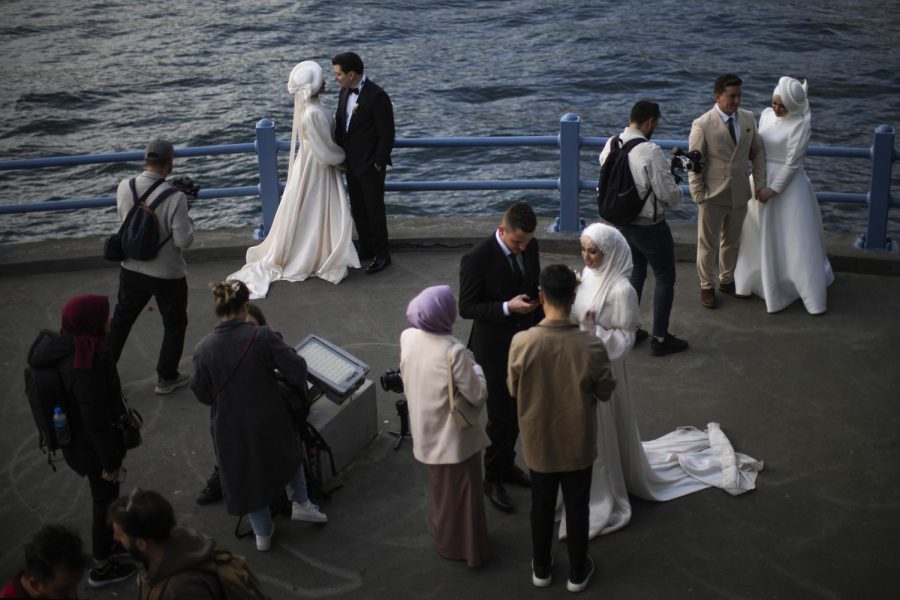 Young couples pose for a video and photo session at Galata bridge in Istanbul, Turkey.